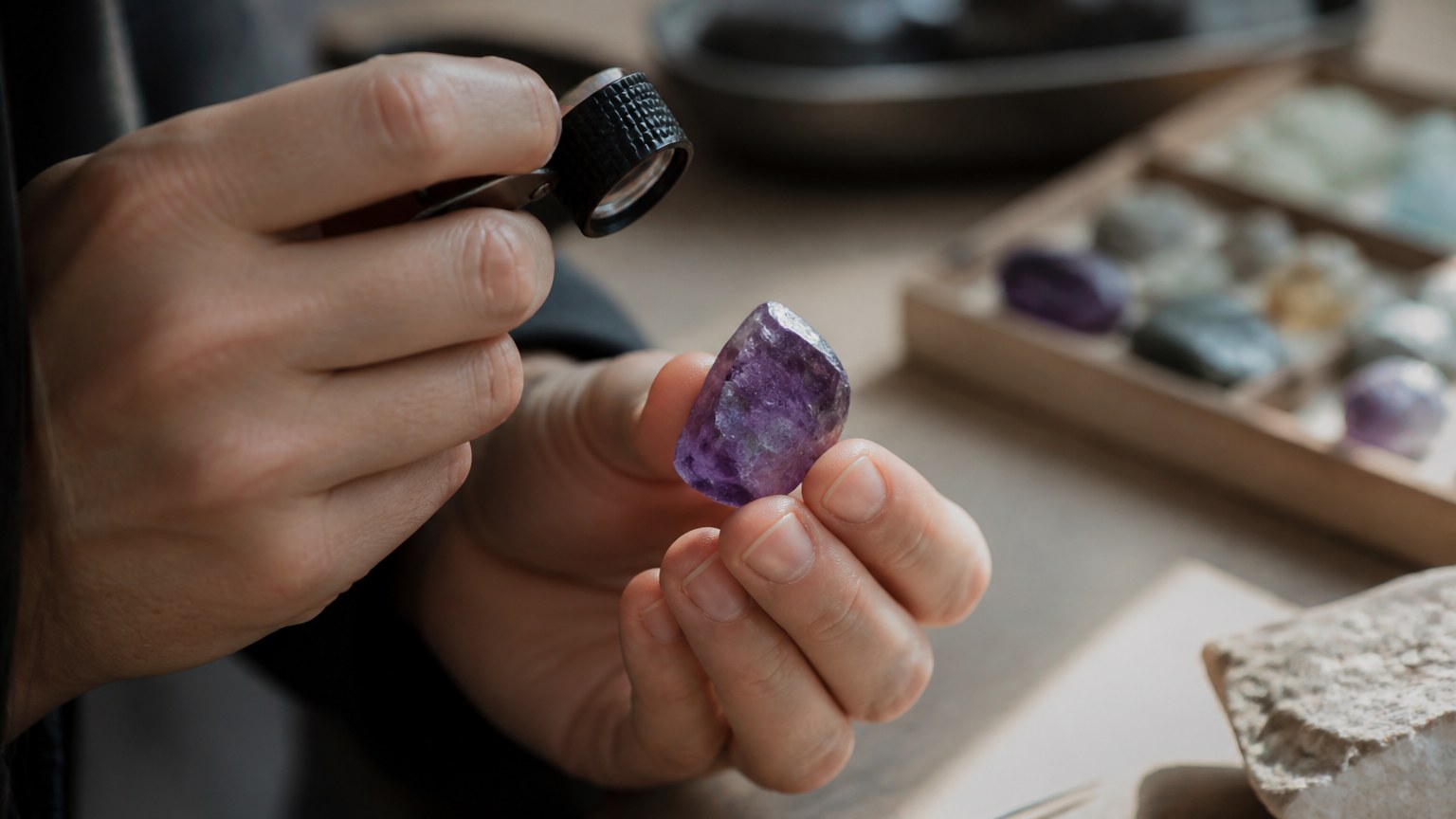 Inspection d’une améthyste brute avec loupe